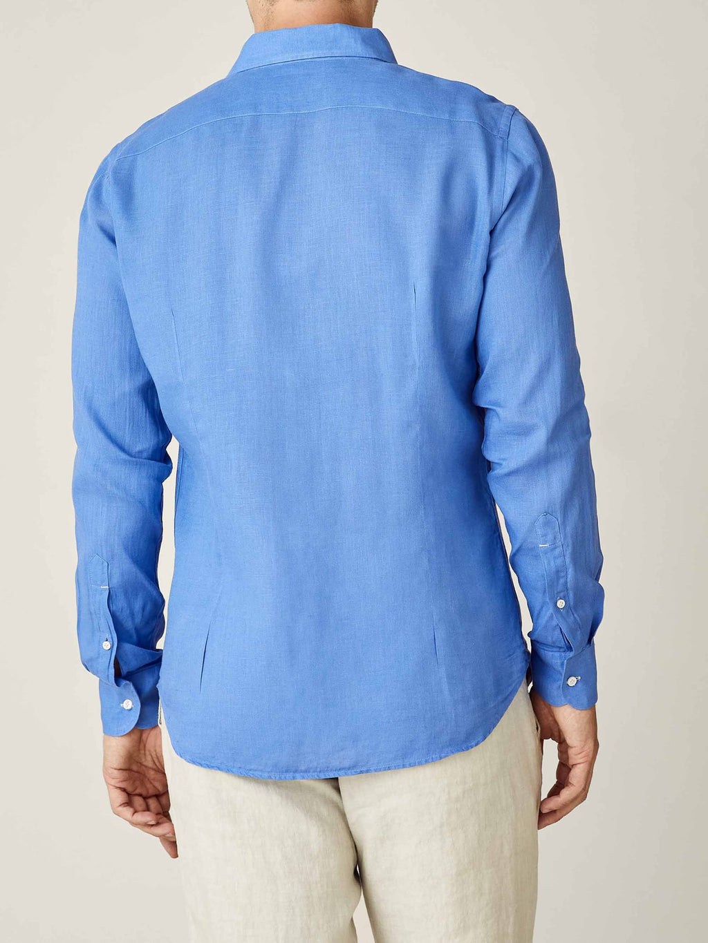 Back view of a model wearing the Portofino Linen Shirt in Capri Blue, highlighting the tailored fit and curved hem.