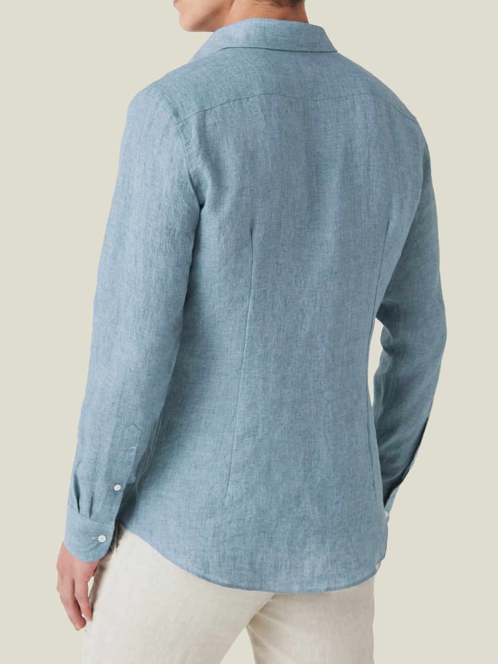 Back view of a man wearing the Portofino Linen Shirt in French Blue, showcasing its tailored fit and curved hem.