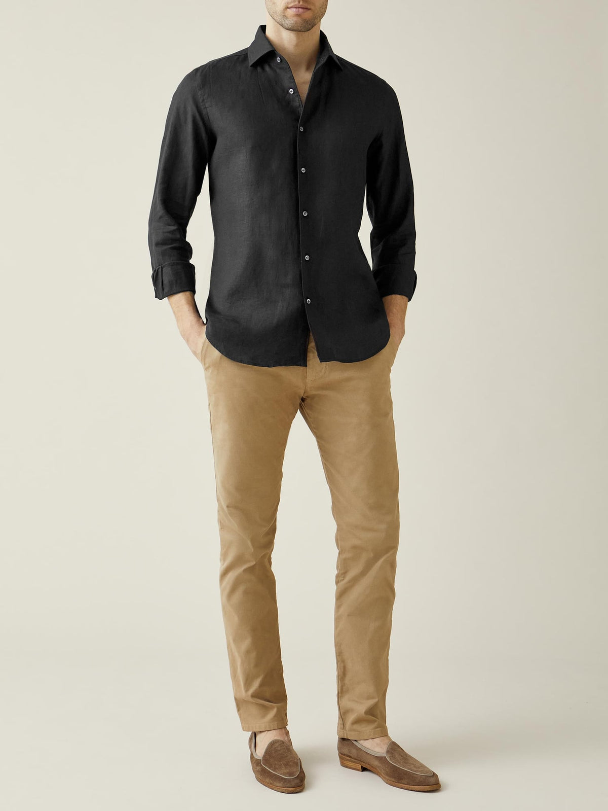 Front view of a model wearing the black Portofino Linen Shirt with camel chinos and brown suede loafers.