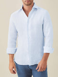 A front view of a model wearing the Luca Faloni Portofino Linen Shirt in Striped Sky Blue with the sleeves rolled up.