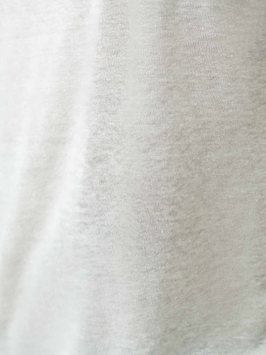 A detailed close-up of the cream linen jersey fabric, showcasing the soft and breathable weave of the Junior T-Shirt.