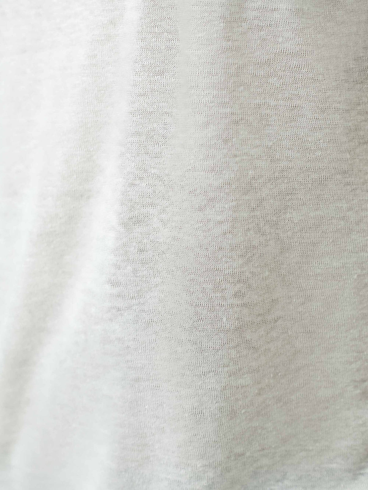 A detailed close-up of the cream linen jersey fabric, showcasing the soft and breathable weave of the Junior T-Shirt.