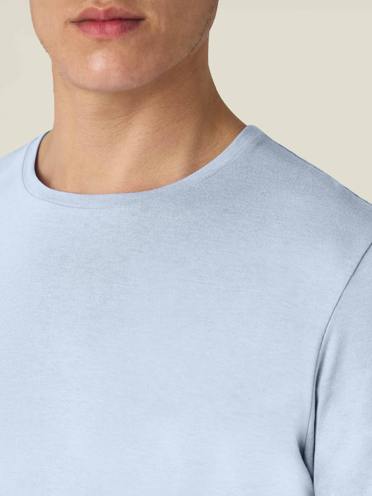 A detailed view of the crew neckline and soft mélange fabric of the Light Blue Cashmere Cotton T-Shirt.