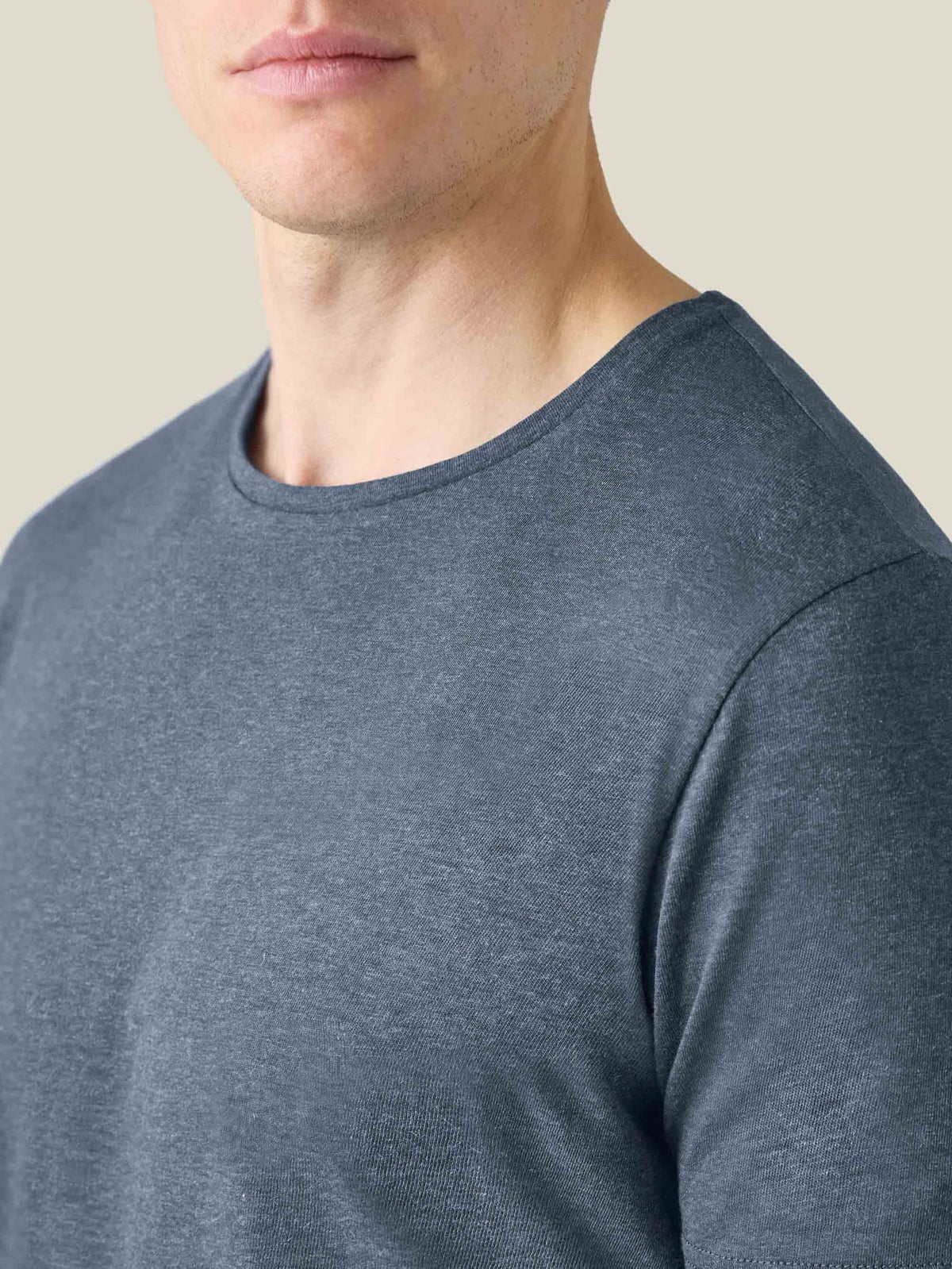 A close-up of the Atlantic Blue Cashmere Cotton T-Shirt's crew neckline and soft mélange fabric, worn by a model.
