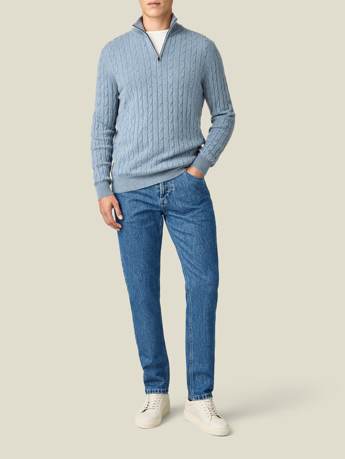 Full body view of a model wearing the Luca Faloni white Cashmere cotton T-Shirt layered under a light blue jumper.