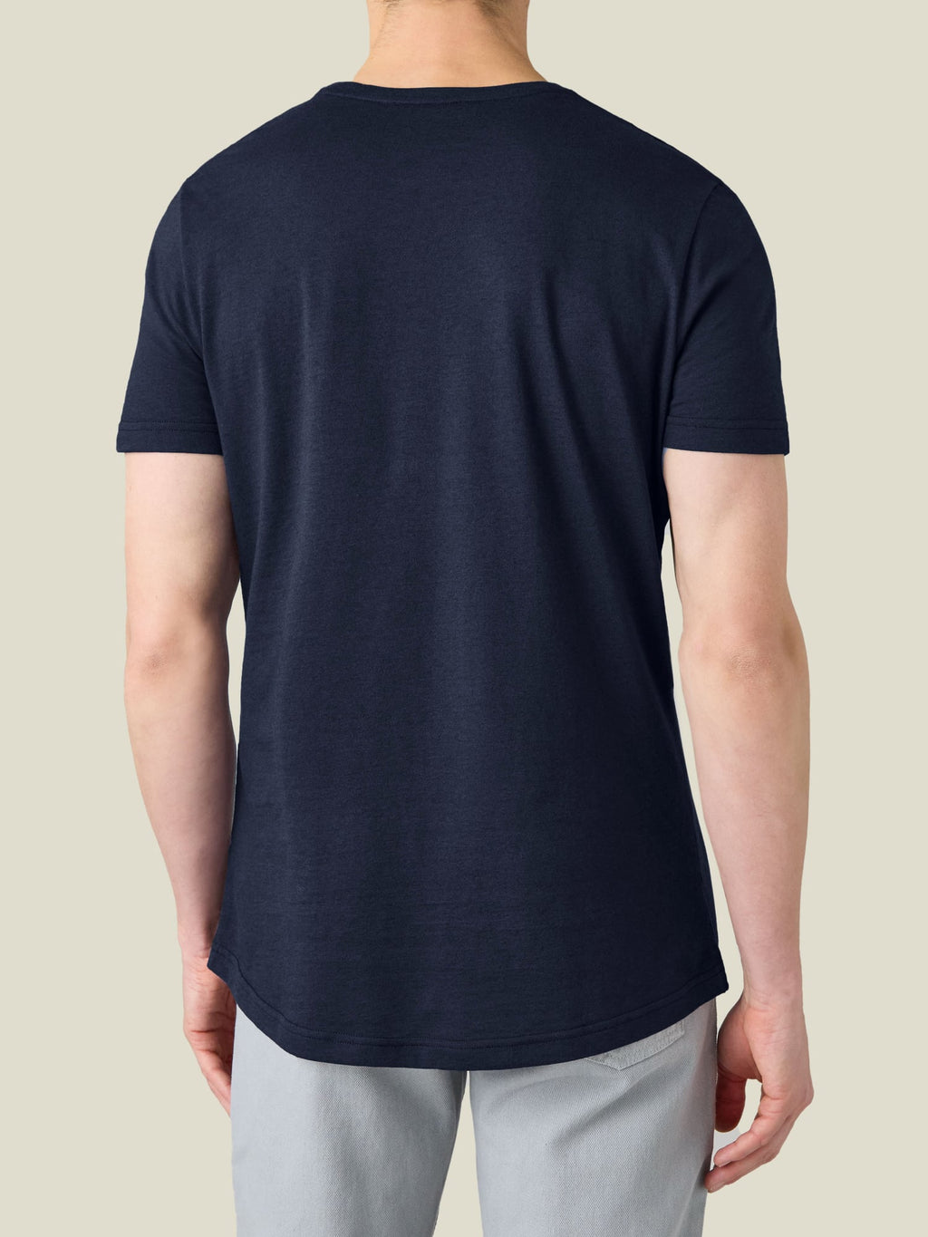 A back view of a model wearing the Luca Faloni Cashmere Cotton T-Shirt in Midnight Blue, highlighting the curved hemline.