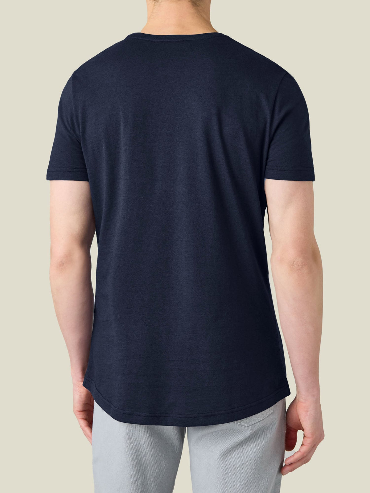 A back view of a model wearing the Luca Faloni Cashmere Cotton T-Shirt in Midnight Blue, highlighting the curved hemline.