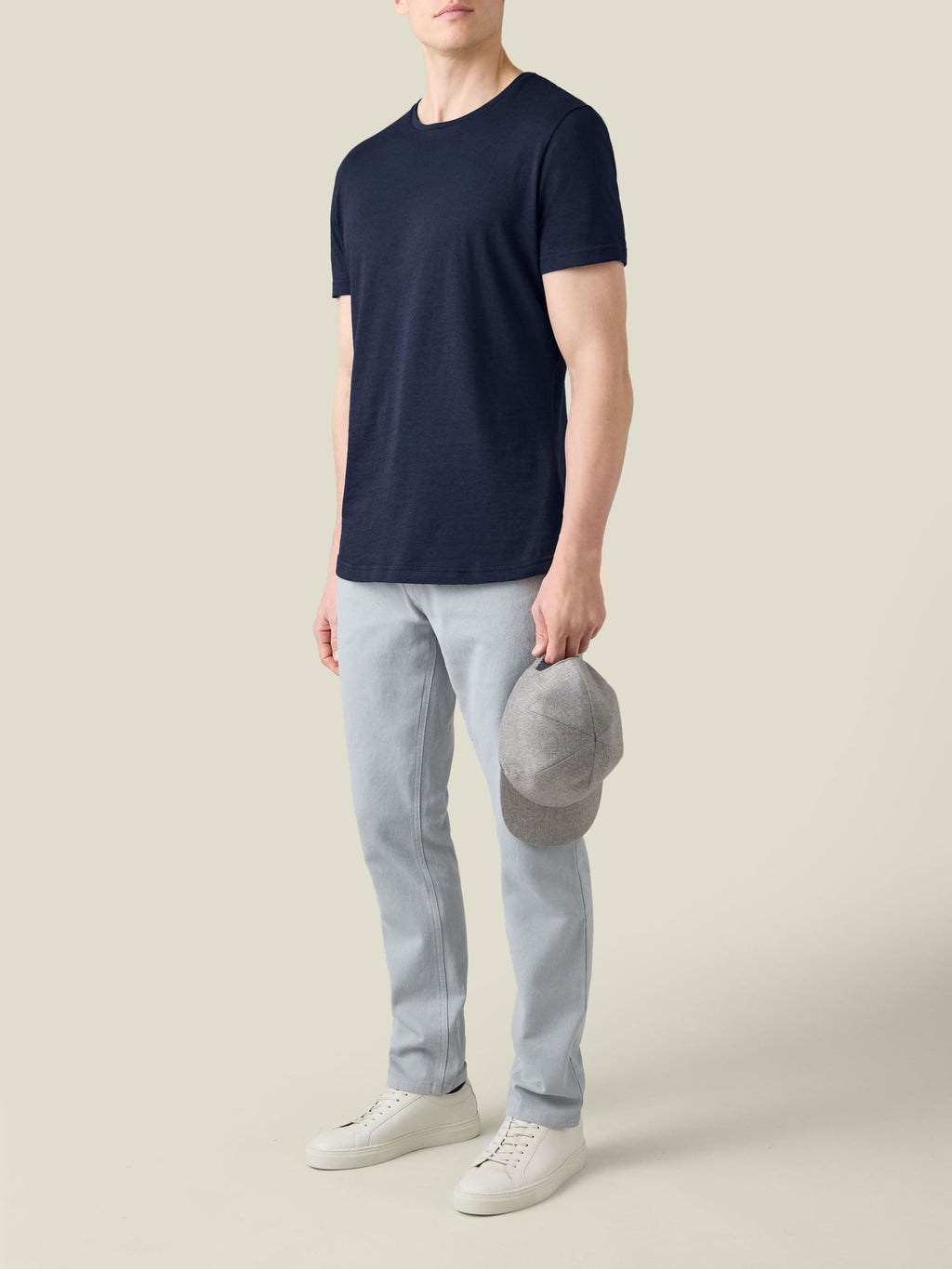 A model wearing the Luca Faloni Midnight Blue Cashmere Cotton T-Shirt, paired with light trousers and white sneakers.