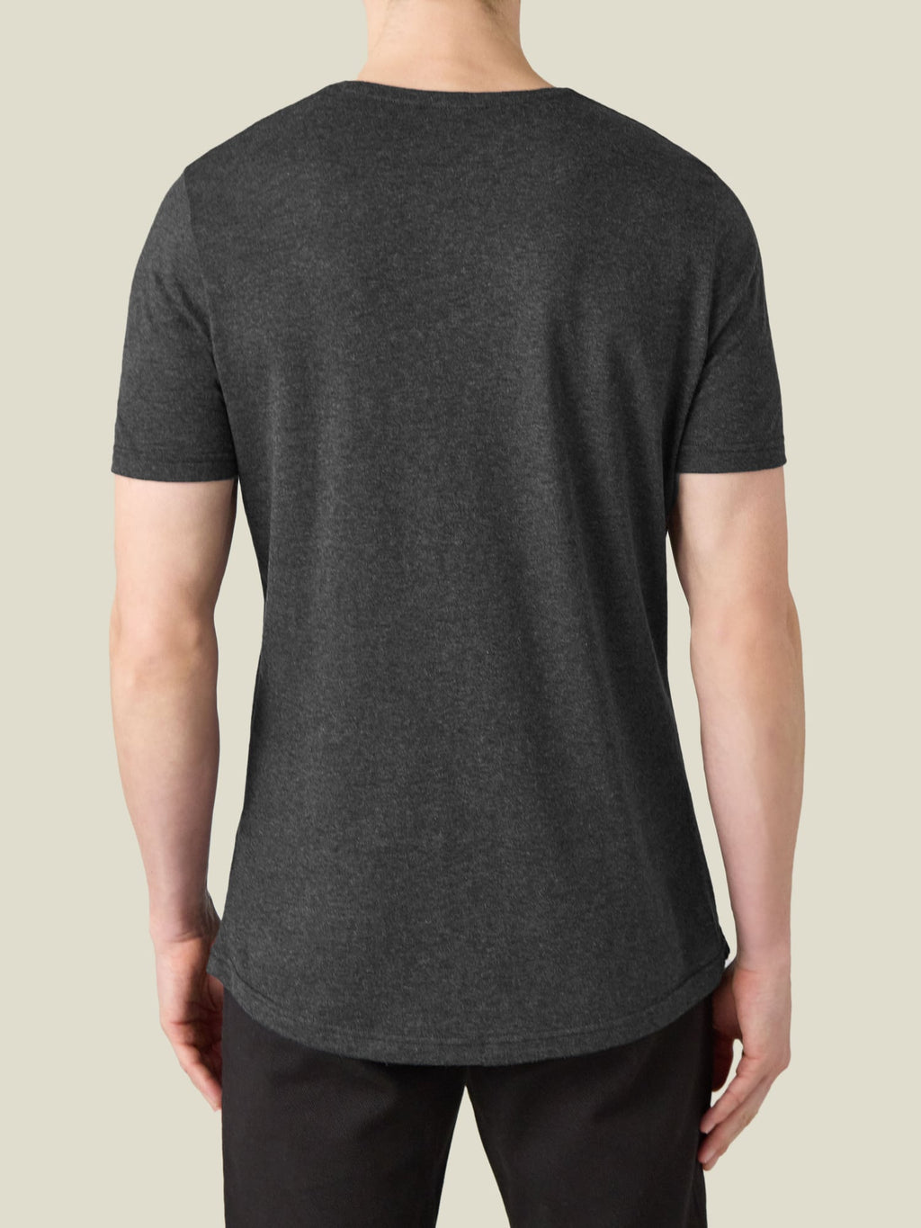 Back of a model wearing the Charcoal Grey Cashmere Cotton T-Shirt, showing its relaxed fit and curved hemline.