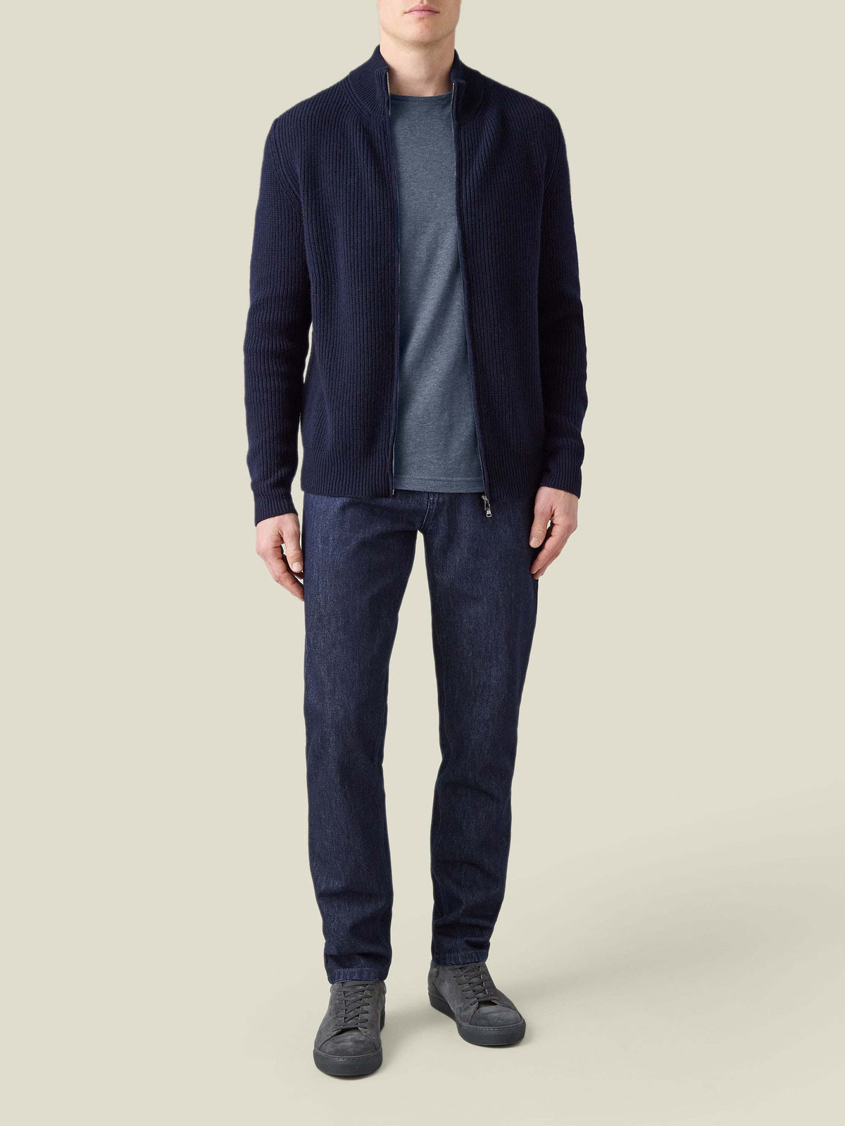 Model wearing the Atlantic Blue Cashmere Cotton T-Shirt, styled with a navy zip cardigan, dark jeans and grey sneakers.