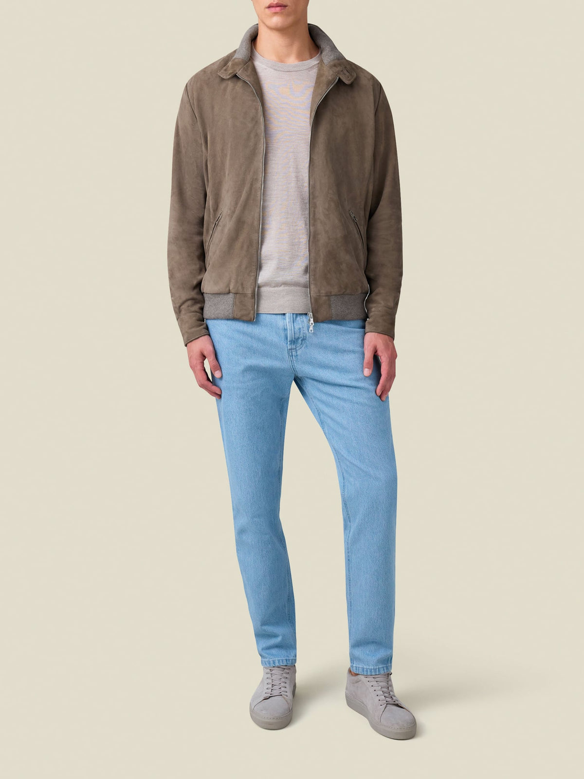 Front view of a model wearing the Hazelnut Brown Classic Bomber Jacket with a beige sweater and light blue jeans.