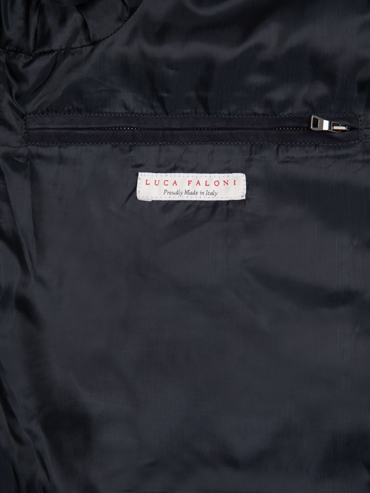 Close-up of the interior of the navy blue Classic Bomber Jacket, showing the premium lining, zipped pocket, and label.
