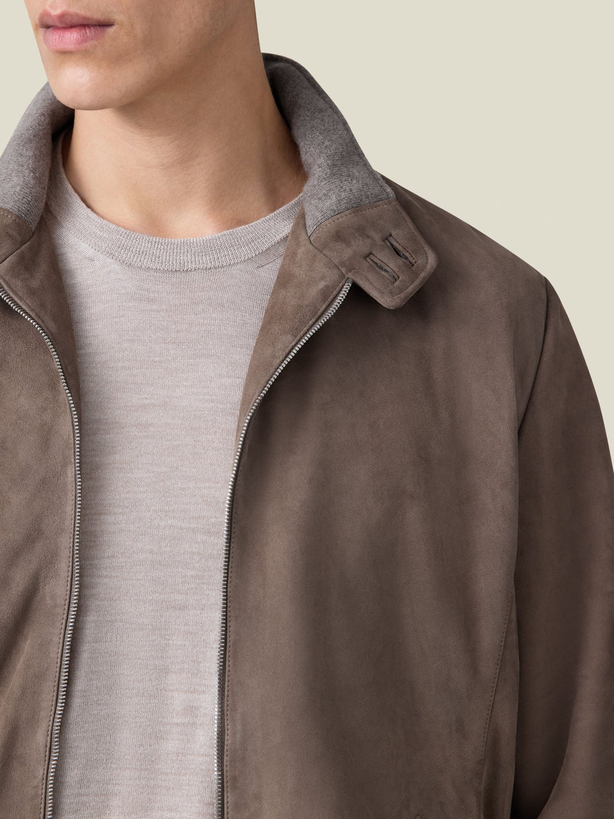 Close-up of a man wearing the Hazelnut Brown Classic Bomber Jacket, showing the goatskin suede and double button collar.