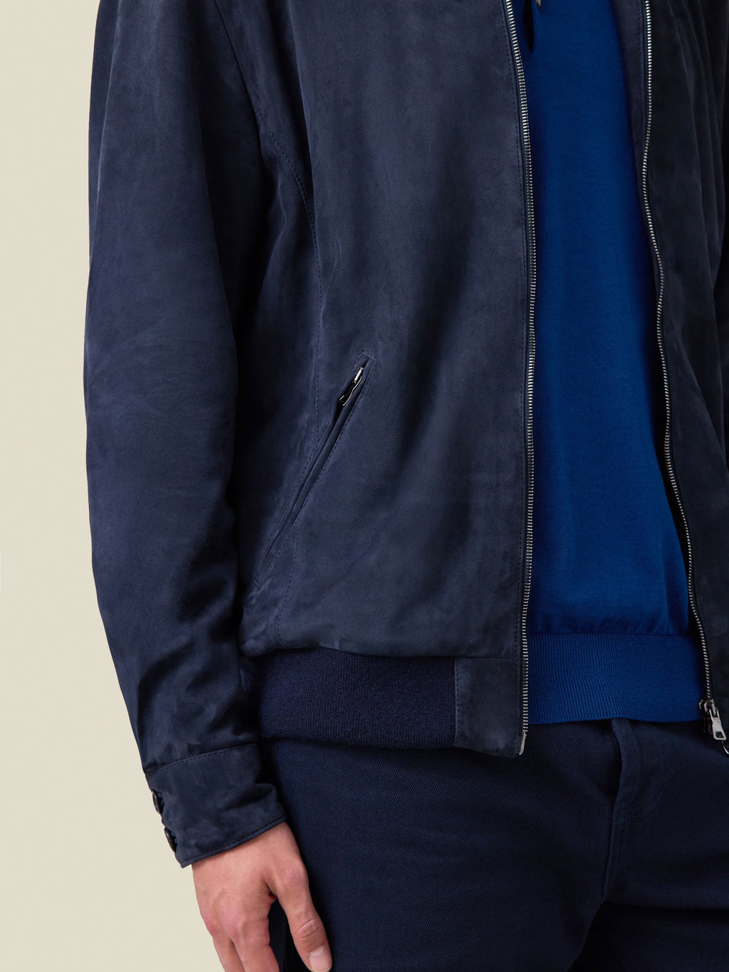 Close-up of the Navy Blue Classic Bomber Jacket in goatskin suede, focusing on the zipped pocket and knitted hem detail.