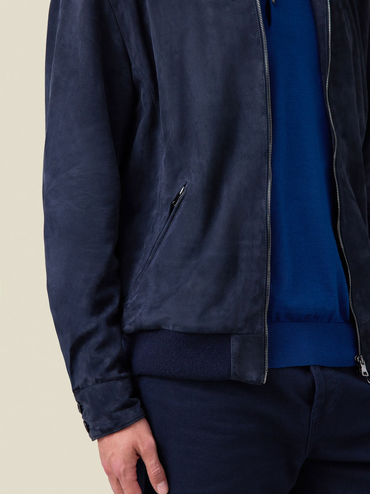 Close-up of the Navy Blue Classic Bomber Jacket in goatskin suede, focusing on the zipped pocket and knitted hem detail.