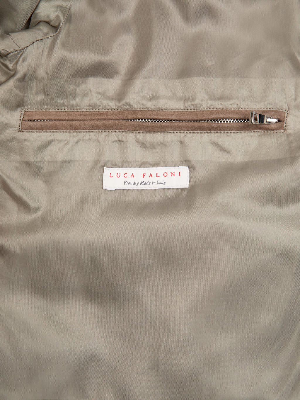 A close-up of the interior of the Hazelnut Brown Classic Bomber Jacket showing the brand label and internal zipped pocket.