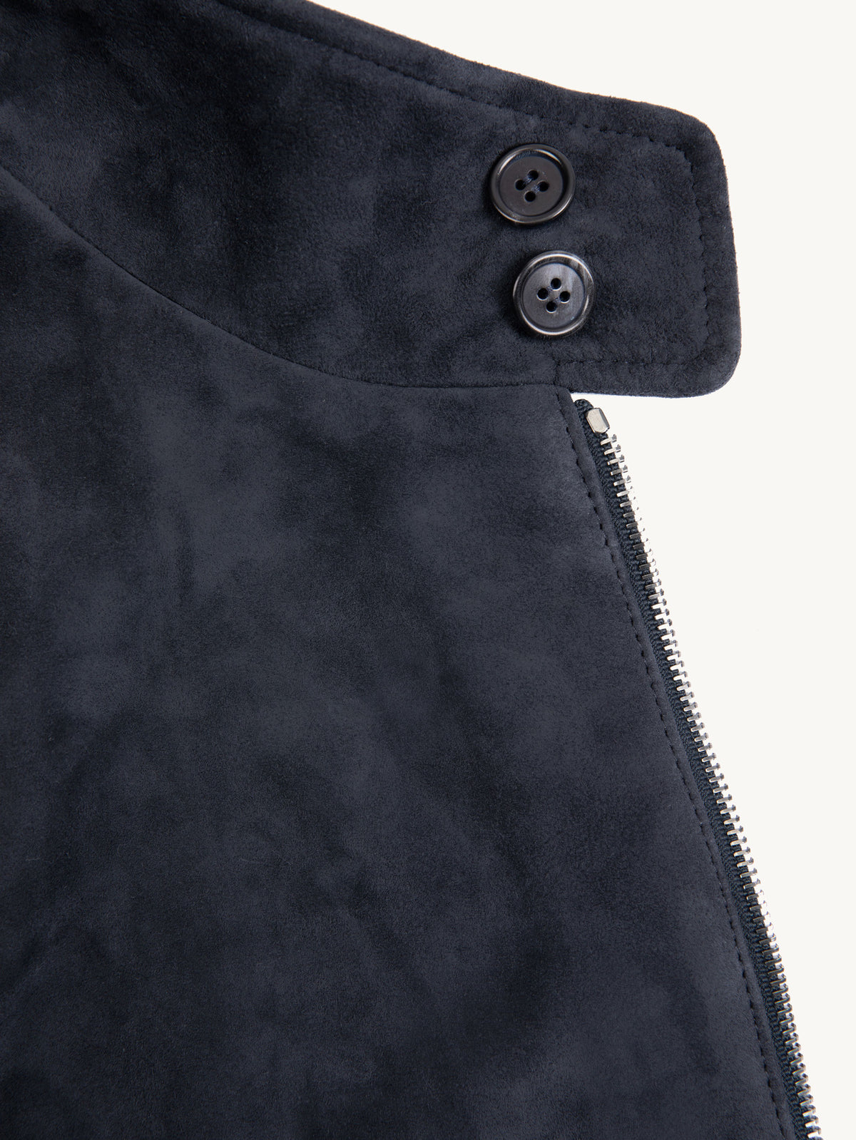 A close-up of the double horn button collar detail on the navy blue goatskin suede Classic Bomber Jacket.