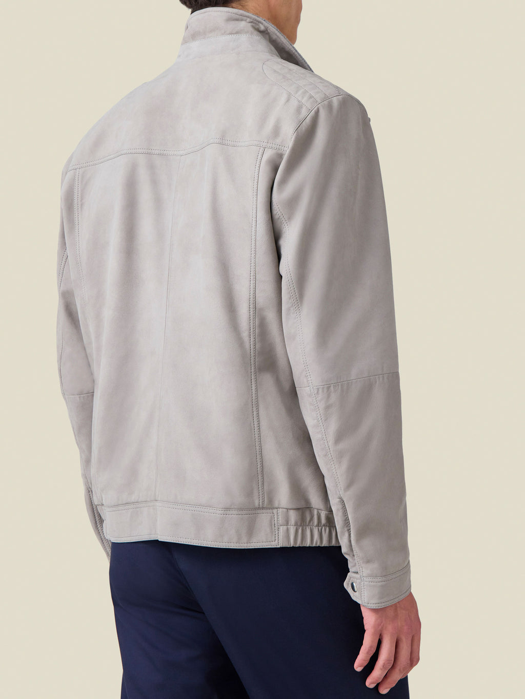 Back view of a man wearing the Classic Racer Jacket in light grey suede, detailing the rear yoke and premium stitching.