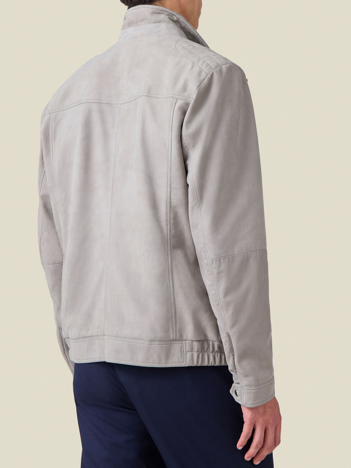 Back view of a man wearing the Classic Racer Jacket in light grey suede, detailing the rear yoke and premium stitching.