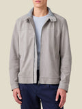 Front view of a model wearing the light grey suede Classic Racer Jacket open over a light blue t-shirt and dark trousers.