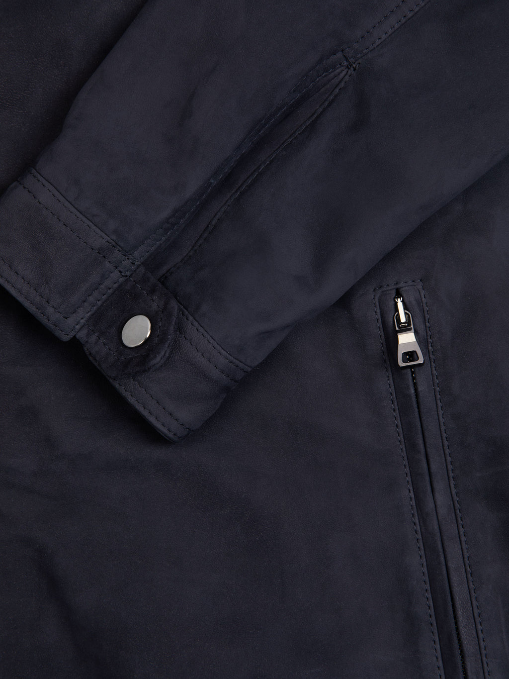 Close-up of the Classic Racer Jacket in navy suede, showing the press-studded cuff and Lanfranchi zip pocket.