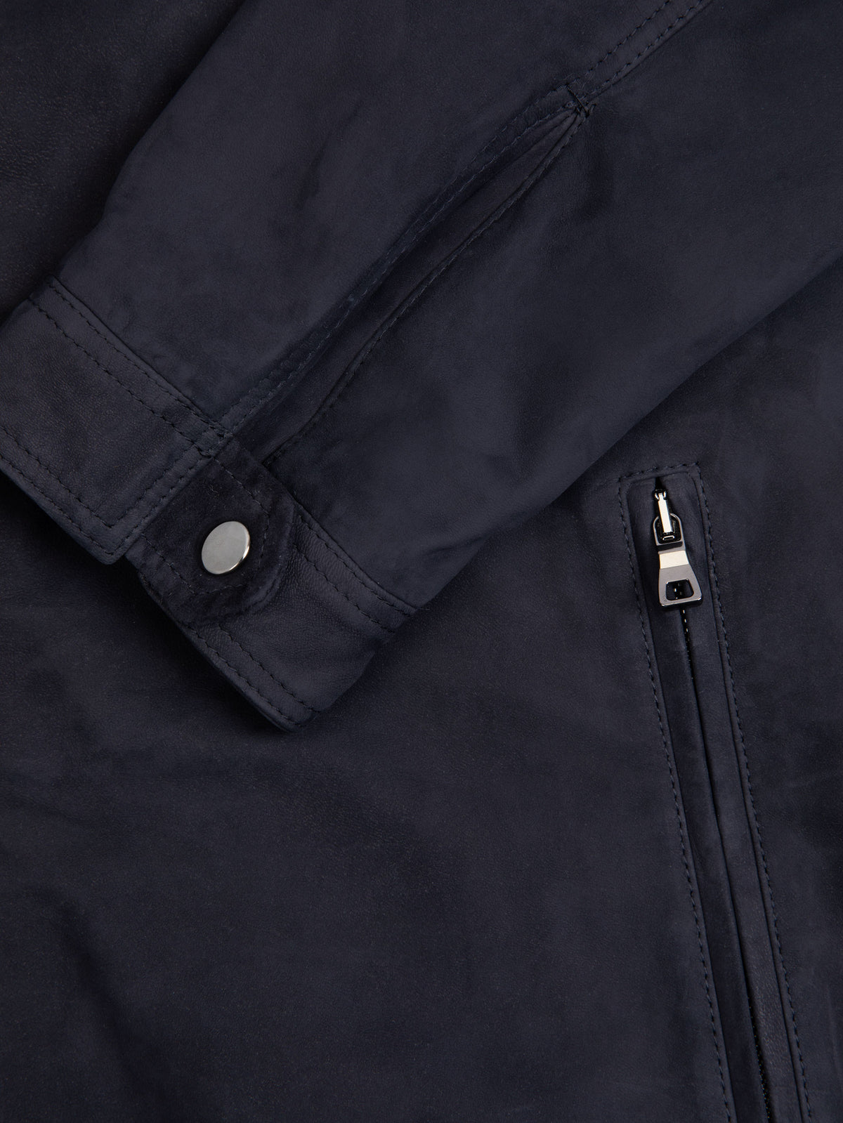 Close-up of the Classic Racer Jacket in navy suede, showing the press-studded cuff and Lanfranchi zip pocket.