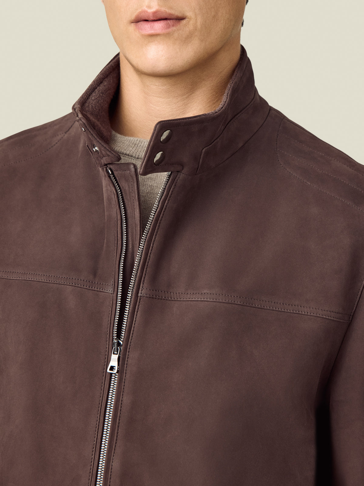 Close-up of a model wearing the Luca Faloni Classic Racer Jacket in chocolate brown, with its cashmere-lined collar and zip.