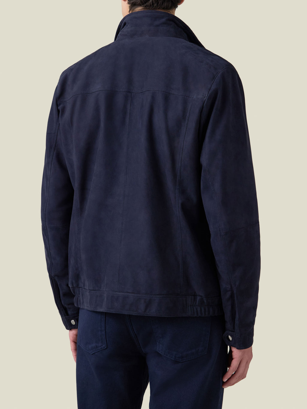 Back view of a model wearing the Classic Racer Jacket in navy blue suede, showcasing the rear yoke and straight hem.
