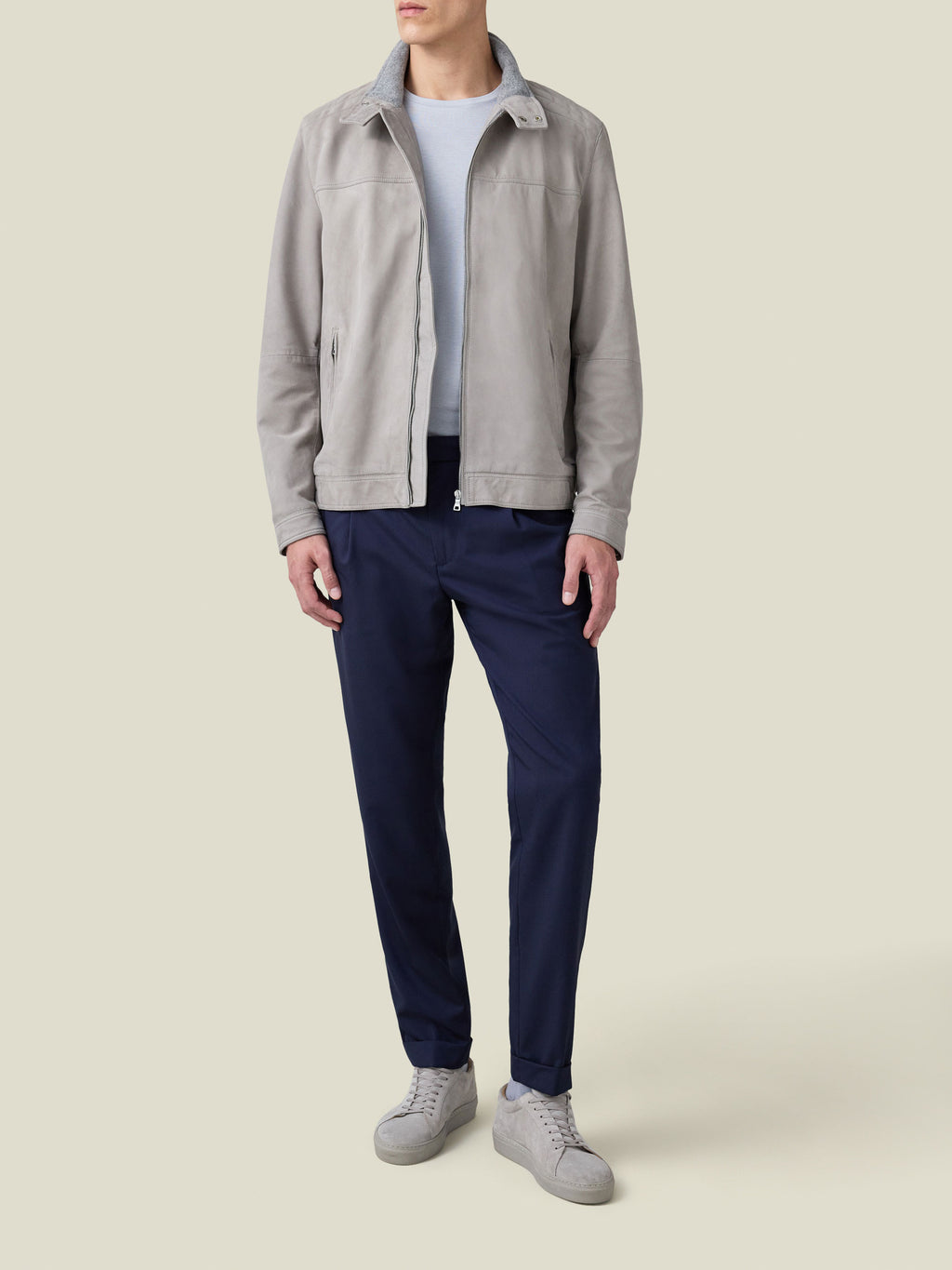 Front view of a model wearing the light grey suede Classic Racer Jacket with navy trousers and grey sneakers.