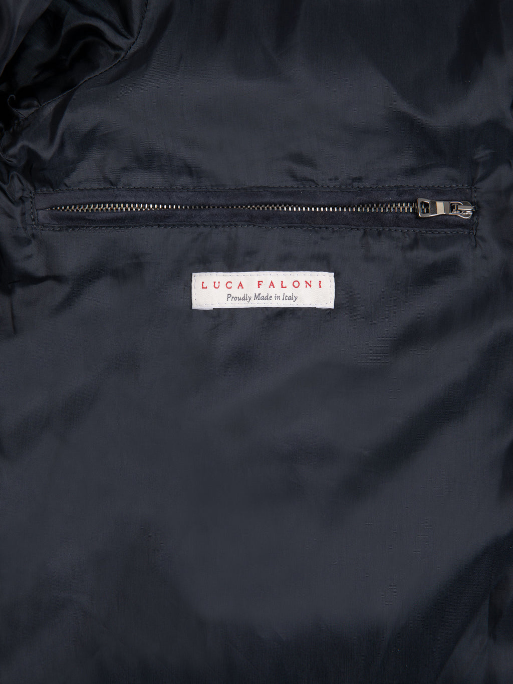 Close-up of the internal zipped pocket and Luca Faloni label inside the navy blue Classic Racer Jacket.