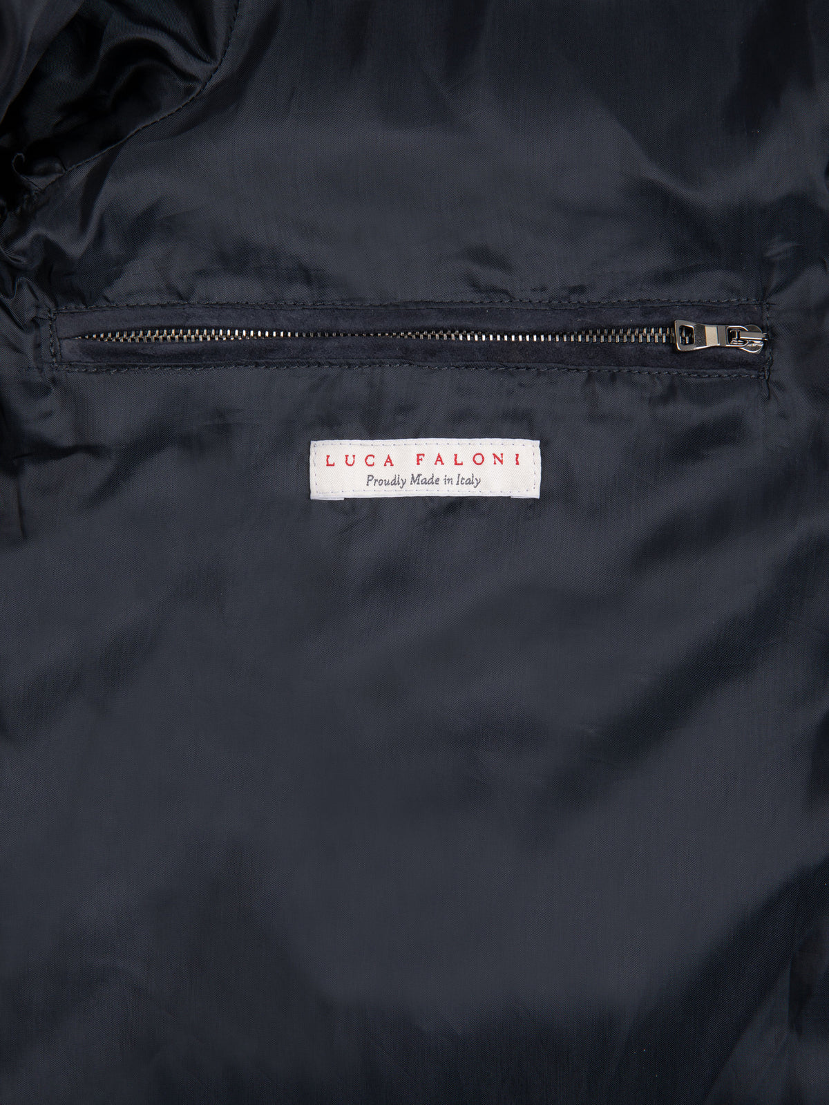 Close-up of the internal zipped pocket and Luca Faloni label inside the navy blue Classic Racer Jacket.