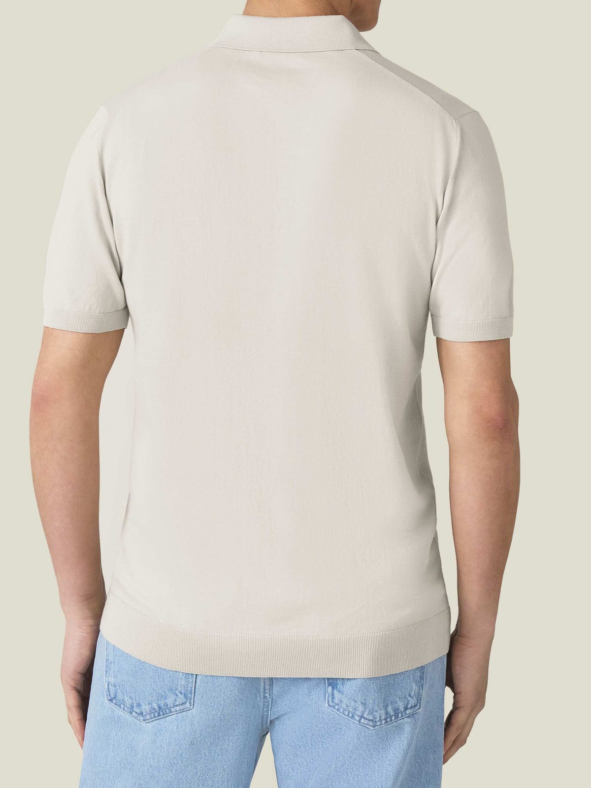 Rear view of a man wearing the Knitted Cotton Polo in Sand.