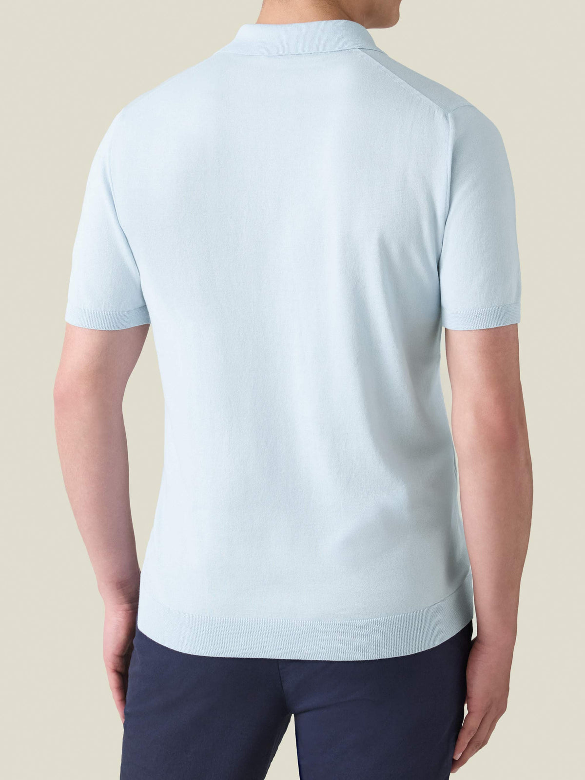 Back view of a model wearing the Knitted Cotton Polo in light blue.