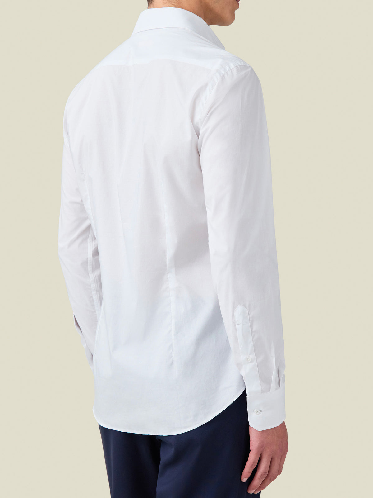 Back view of a model wearing the White Lightweight Poplin Cotton Shirt, showcasing its tailored fit and curved hem.
