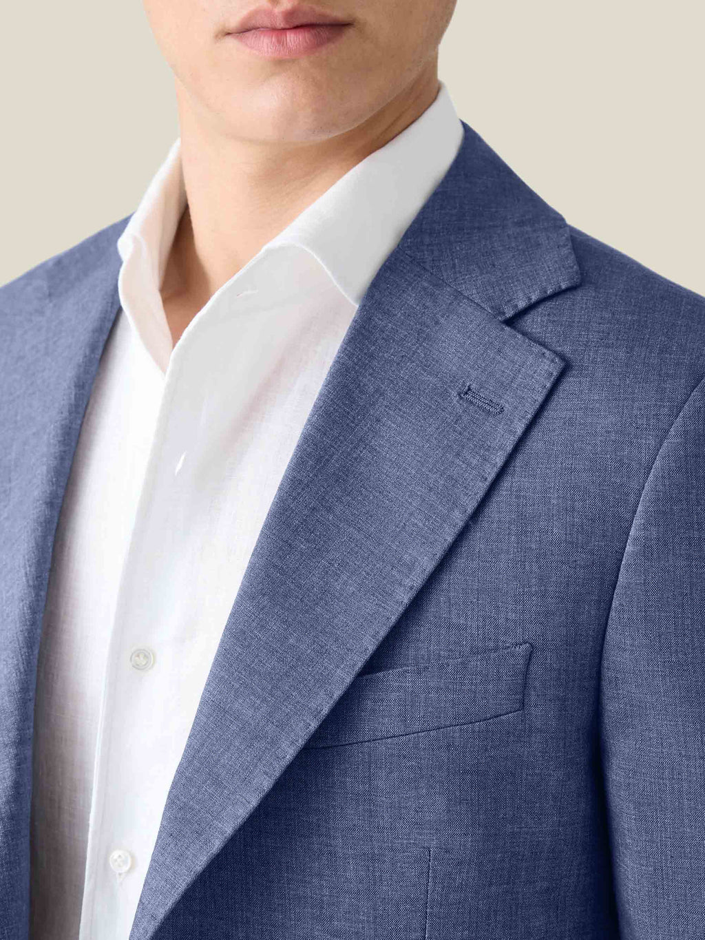 A close-up of the Luca Faloni Azure Linen Suit, showcasing the blazer's fine texture, notch lapel, and welt chest pocket.