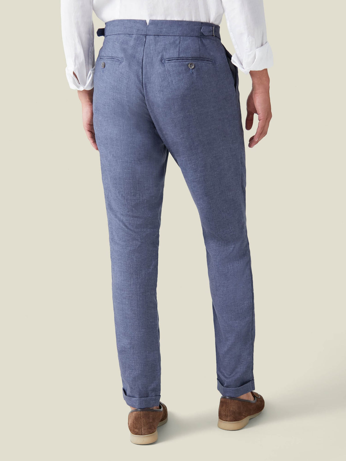 Back view of a man wearing the Azure Linen Trousers, highlighting the slim fit, back pockets, and adjustable side tabs.
