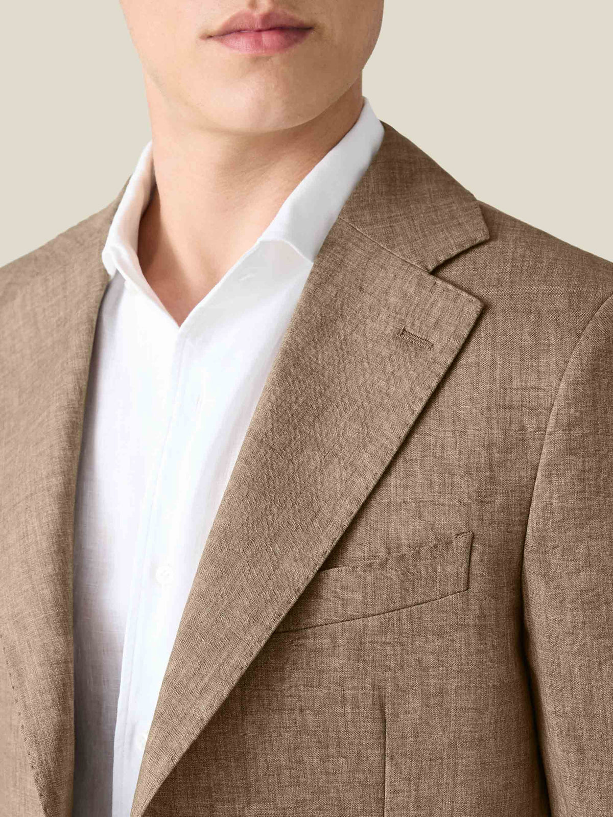Close-up of the Luca Faloni Hazelnut Brown Linen Suit, highlighting the blazer's textured fabric and notched lapel.