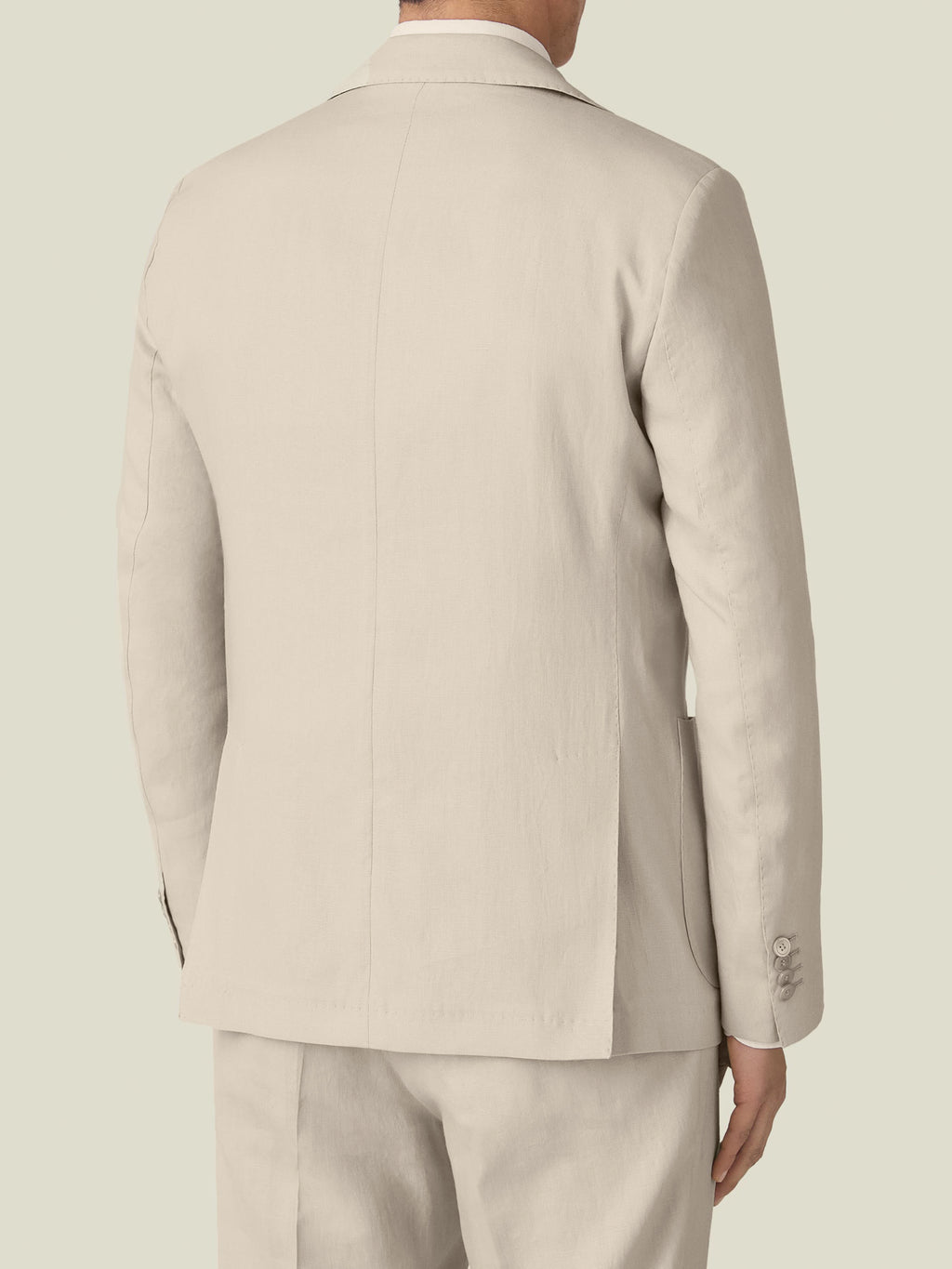 Rear view of a man wearing the Sand Linen Suit, highlighting the tailored fit and double vents of the blazer.