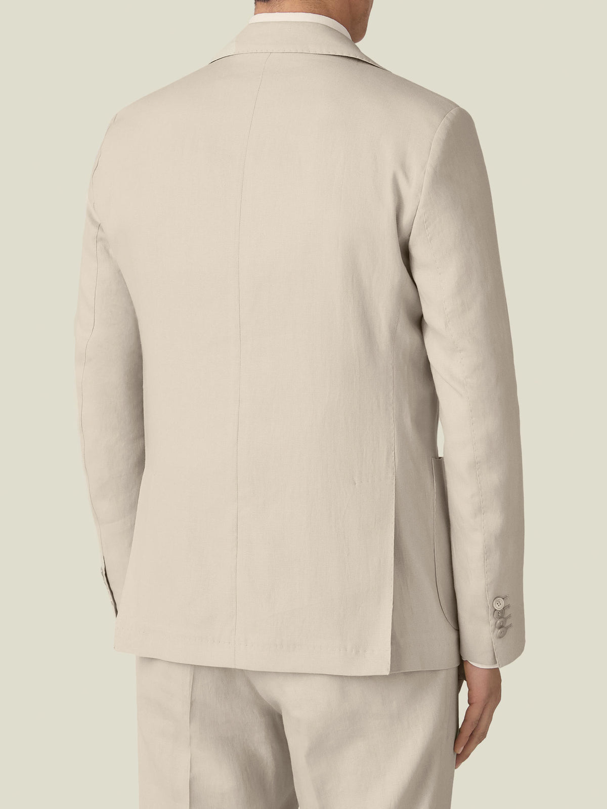 Rear view of a man wearing the Sand Linen Suit, highlighting the tailored fit and double vents of the blazer.