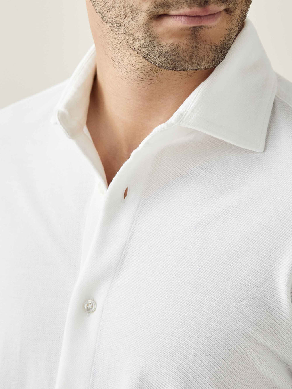 Close-up of the Luca Faloni white Silk-Cotton Piqué Shirt, detailing the cutaway collar and diamond textured fabric.
