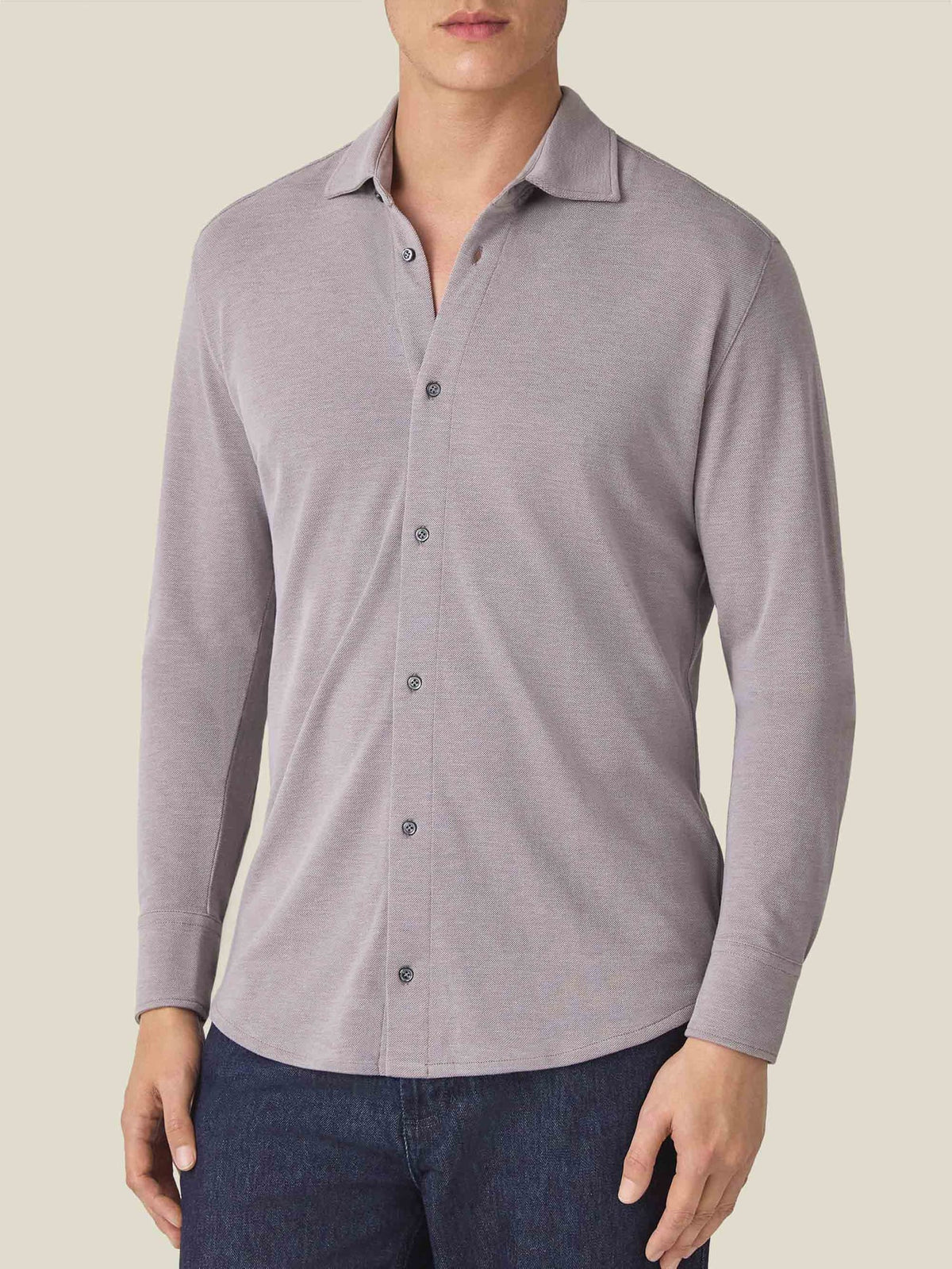 Front view of a model wearing the Silk-Cotton Piqué Shirt in Nocciola Brown, paired with dark blue jeans.