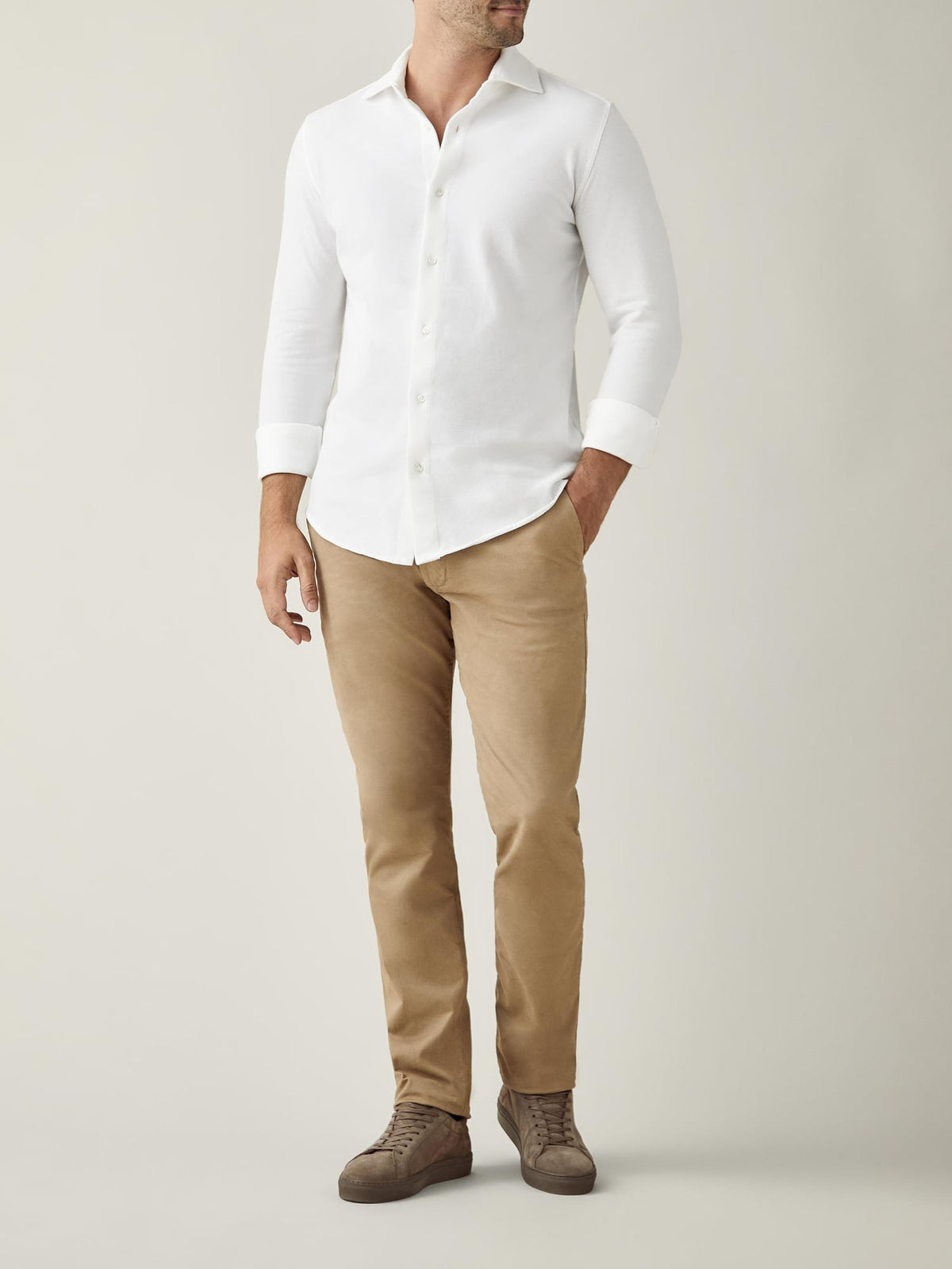 Full shot of a model wearing the white Silk-Cotton Piqué Shirt with light brown trousers and brown suede shoes.