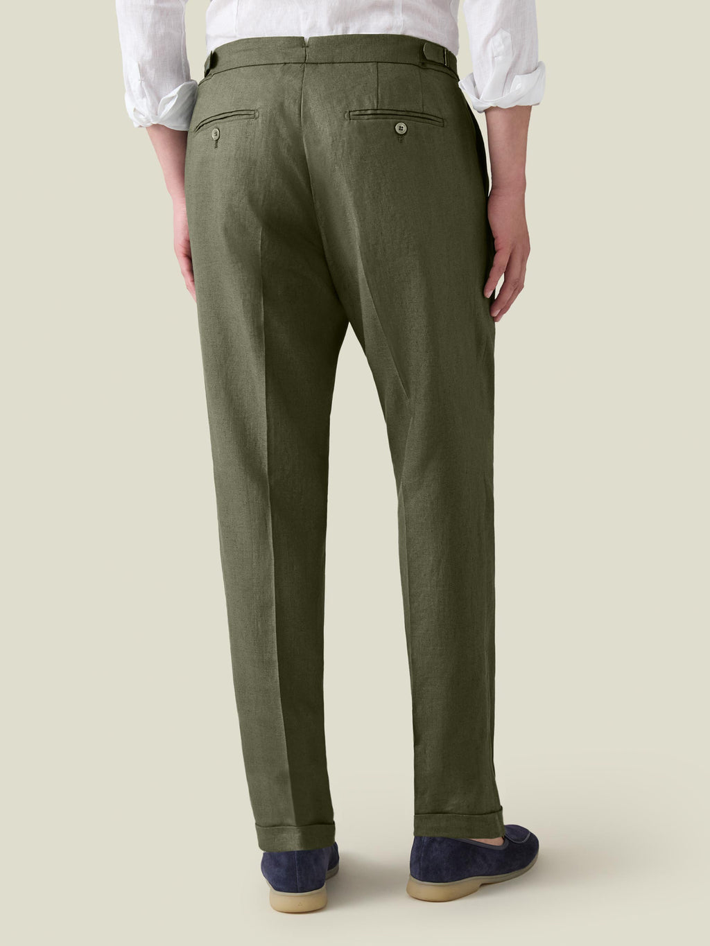 Rear view of a man wearing Luca Faloni's Olive Green Linen Elegant Trousers, showing the tapered fit and back details.