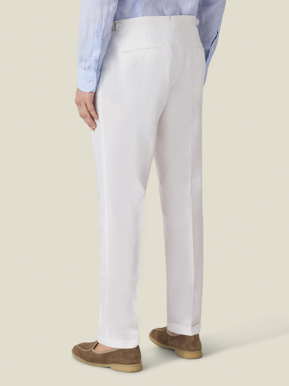 Back view of the Luca Faloni Linen Elegant Trousers in white, styled with a blue shirt and brown suede loafers.