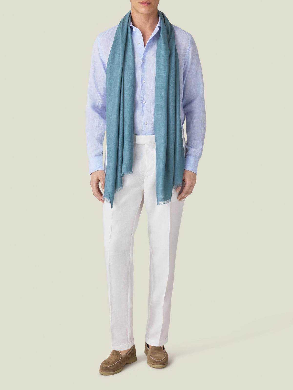 A model showcases Luca Faloni's White Linen Elegant Trousers, styled with a light blue shirt, teal scarf, and brown loafers.