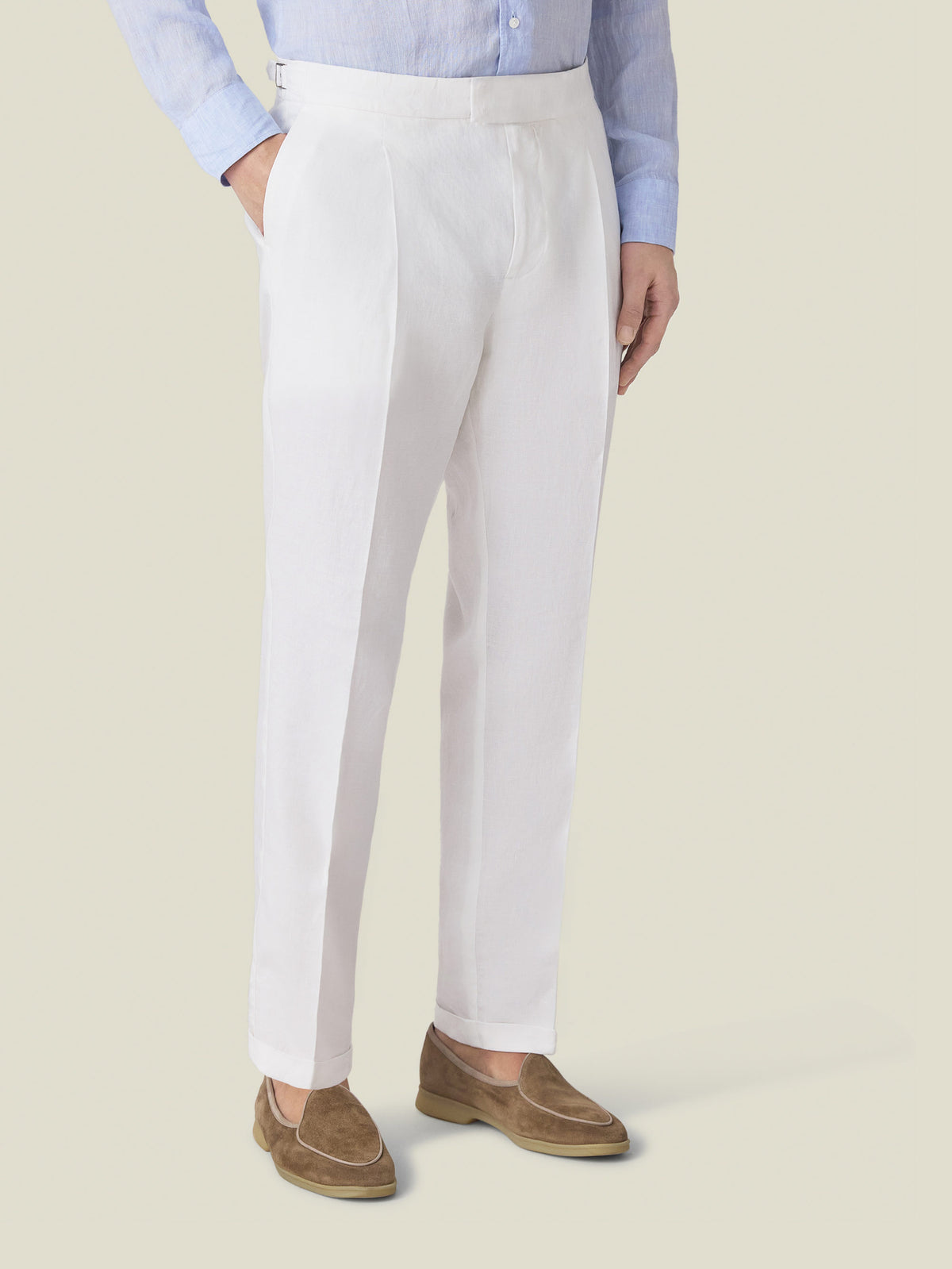 A model wears the Luca Faloni Linen Elegant Trousers in white, showcasing the tapered fit and single front pleat.