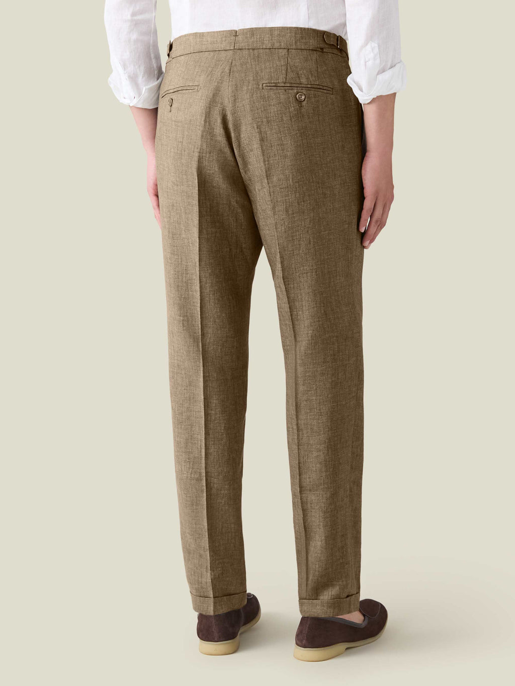 Back view of a model wearing Luca Faloni's Hazelnut Brown Linen Elegant Trousers with a white shirt and dark brown loafers.