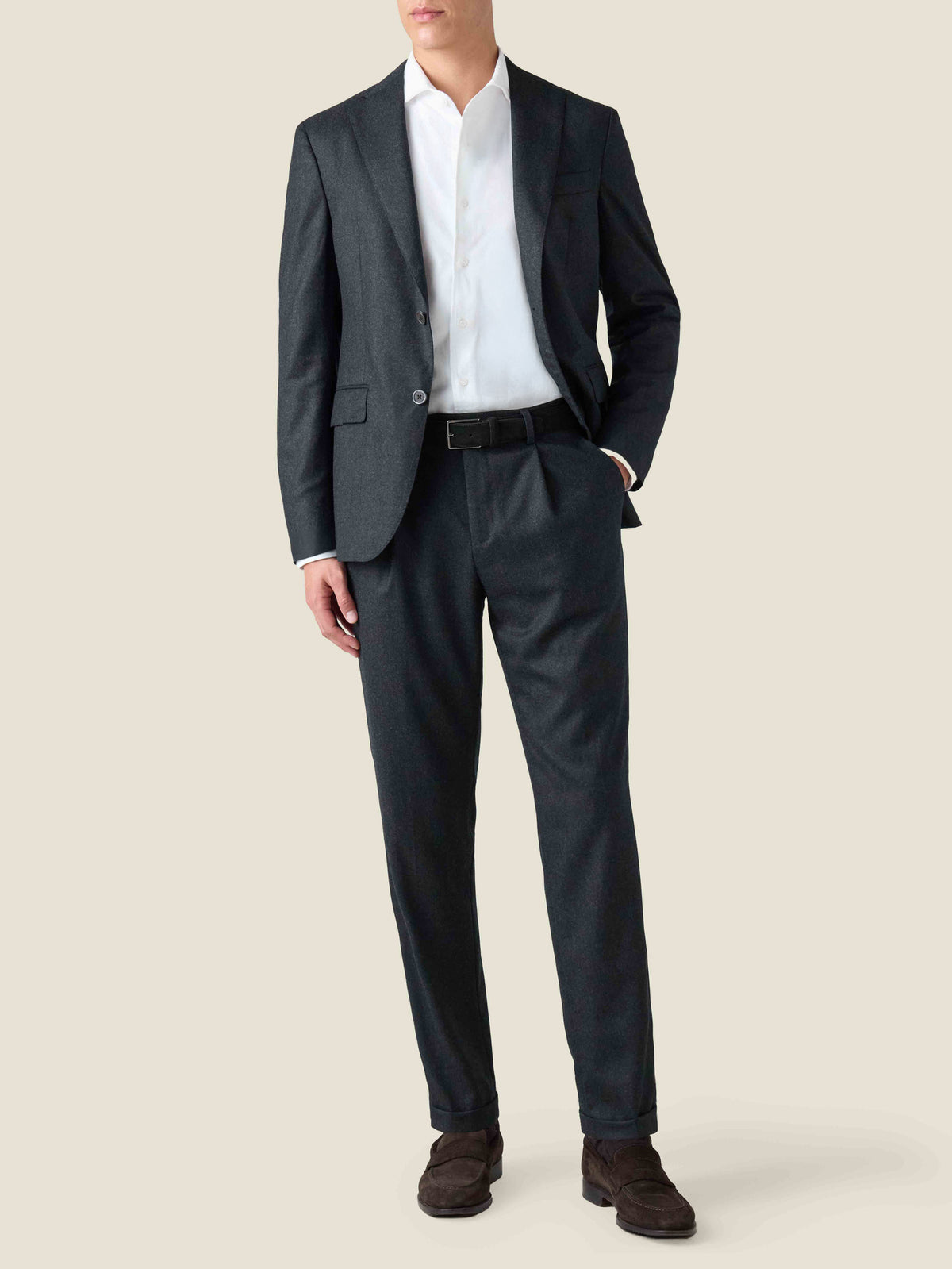 A front view of a model wearing the Luca Faloni Wool Suit in Charcoal Grey, styled with a white shirt and dark brown loafers.