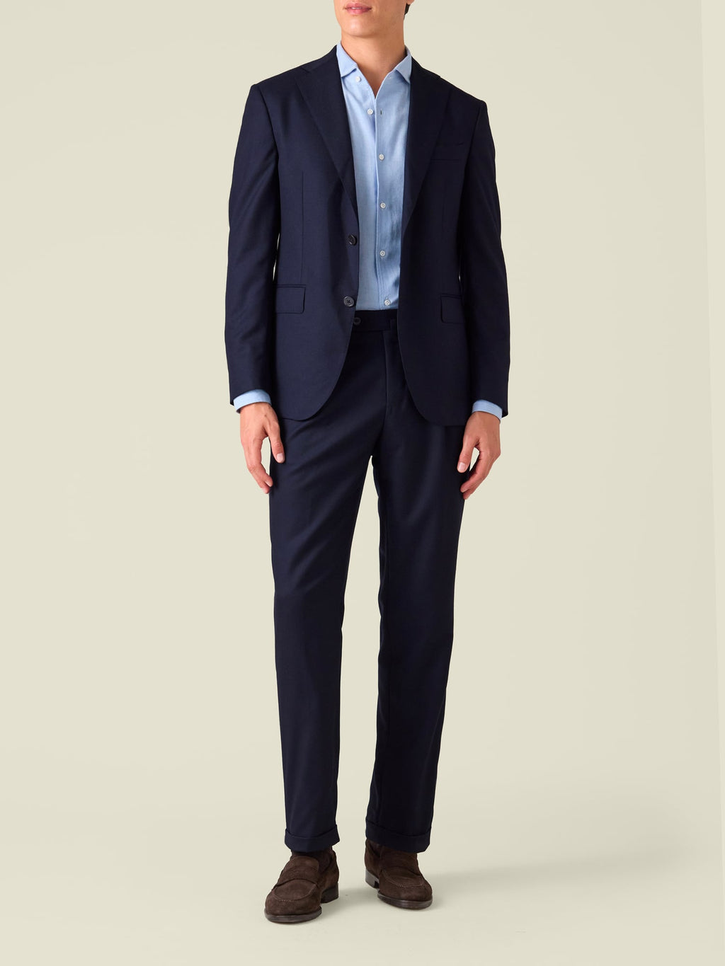 Front view of a model wearing midnight blue Classic Wool Trousers with a matching blazer, light blue shirt, and loafers.