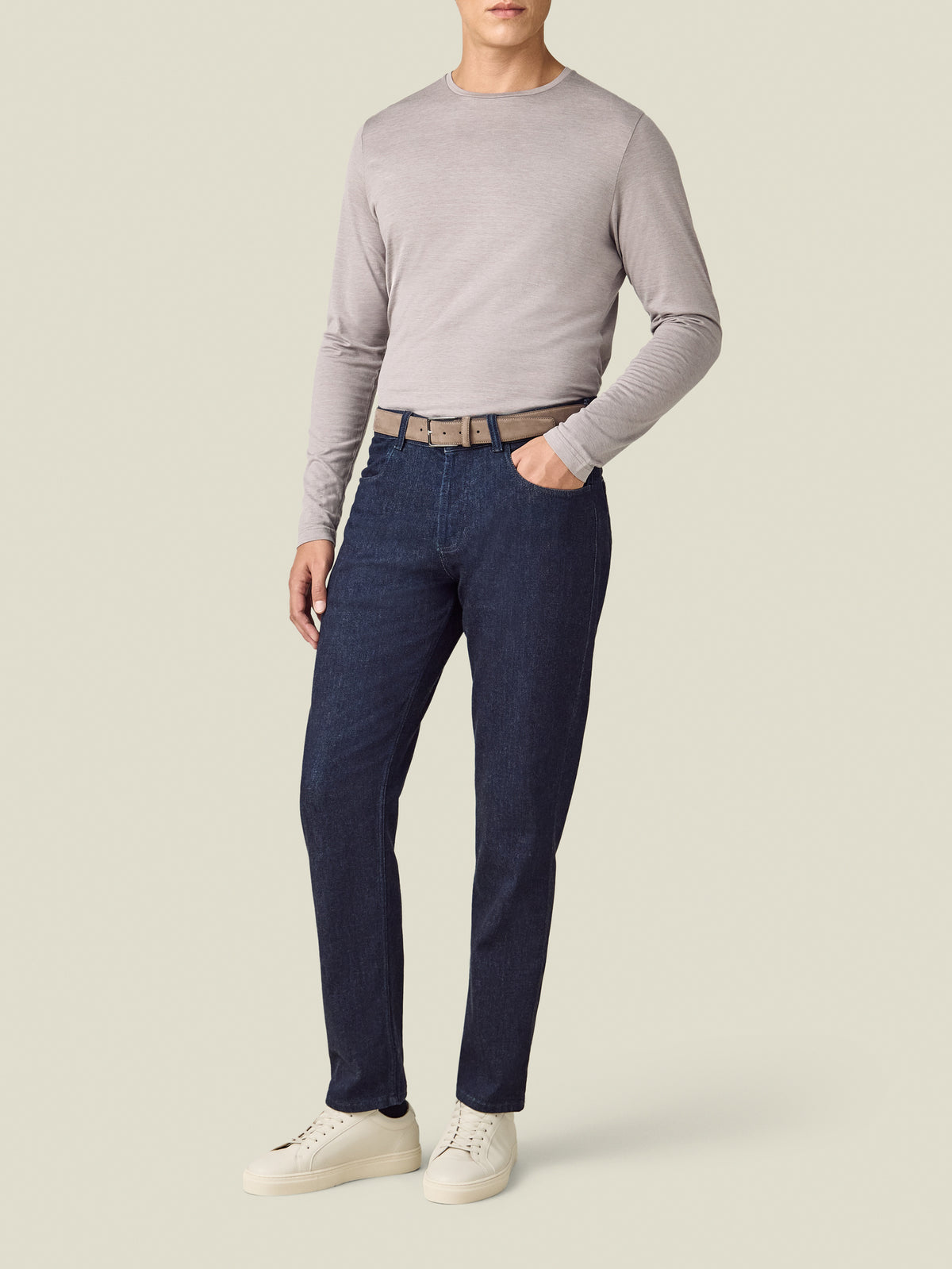 Model wearing the Luca Faloni dark blue Cashmere Denim Jeans with a grey top and white trainers.
